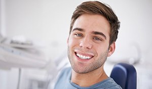 Young man in dental chair smiling