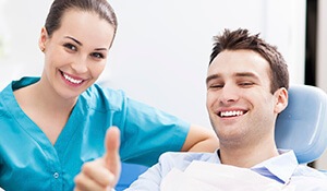 Man gives thumbs up with dental assistant