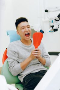 Man at dentist looking at parts of mouth