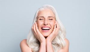 An older woman happy with her new dental implants