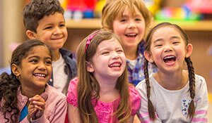 Five children laughing in classroom