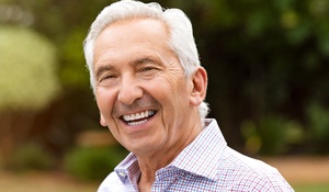 Older man with dentures smiling