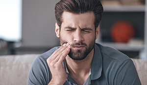 Young man holding side of face