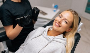 Patient reclined in treatment chair smiling