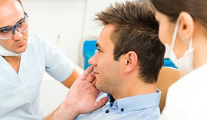 Man with dentist and assistant