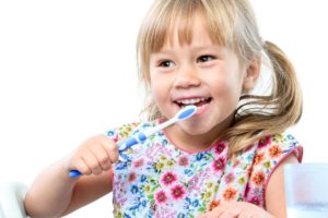 little girl with pigtails brushing her teeth
